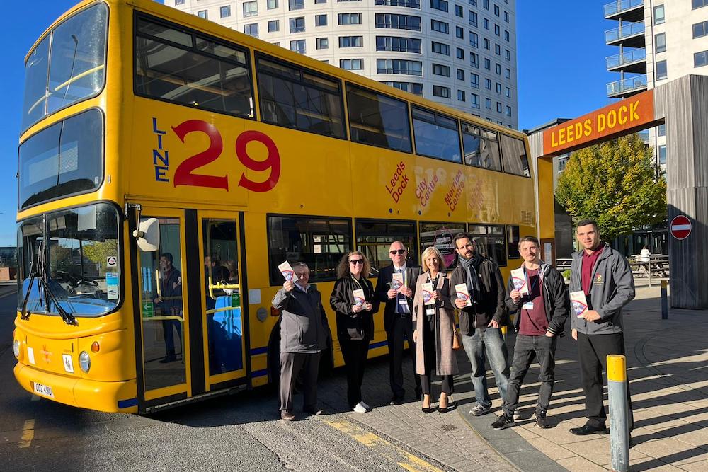 A group of people including Councillors and Yorkshire Buses staff in front of a number 29 bus at Leeds Dock