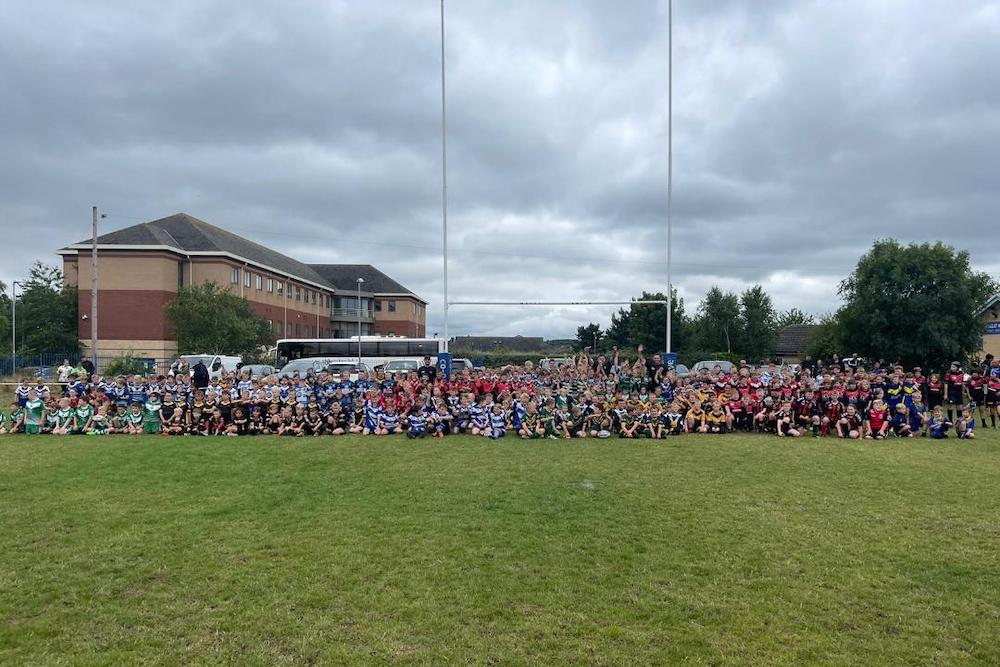 Hundreds of young rugby players line up in front of the rugby posts at Hunslet Warriors