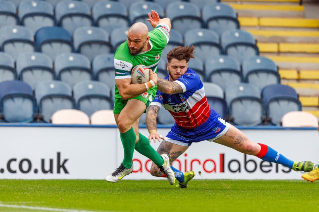 Adam Ryder for Hunslet breaks the tackle of a Rochdale player to score