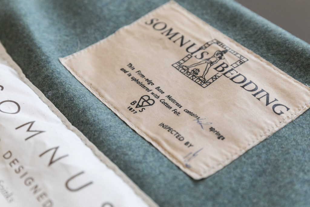 The 100-year-old bed's original label with the company's old Somnus branding, restitched into the new fabric