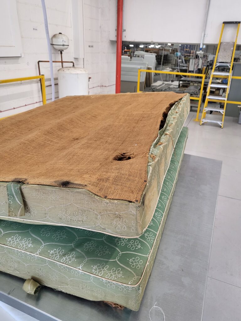 The old original bed, collected by Harrison Spinks to refurbish and folded in half at the hinge for transportation